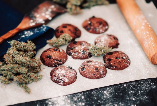 Sweets with weed. Chocolate cookies with marijuana. Sweets with cannabis. Cannabis buds on a black background. Baking with the addition of CBD.