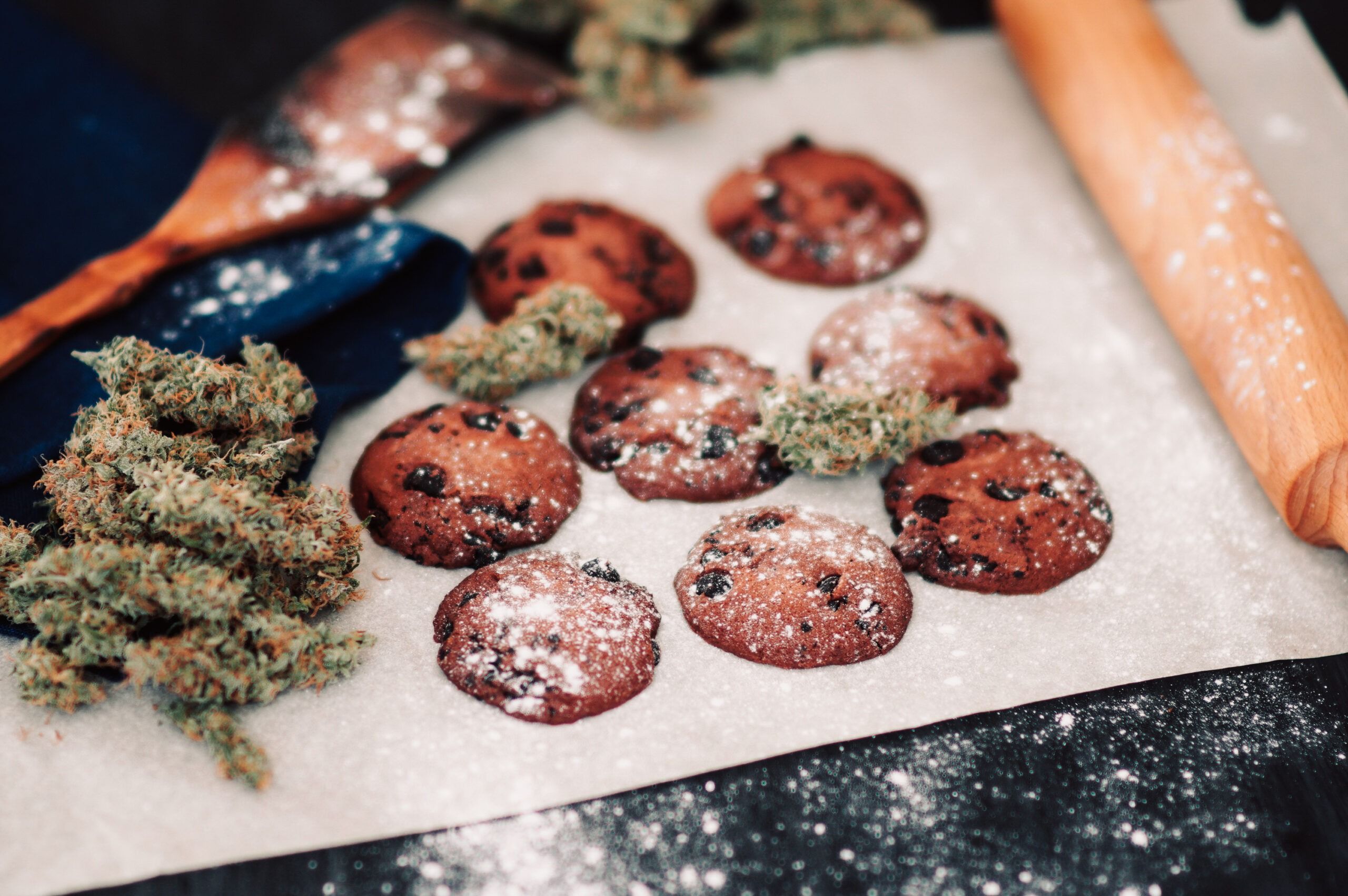 Sweets with weed. Chocolate cookies with marijuana. Sweets with cannabis. Cannabis buds on a black background. Baking with the addition of CBD. Sweets with weed. Chocolate cookies with marijuana. Sweets with cannabis. Cannabis buds on a black background. Baking with the addition of CBD.